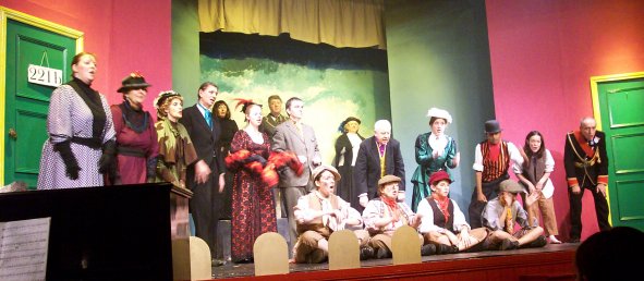 Back row: Gorgiano, Moriarty, Chorus. Main row: Tillie, Mrs Hudson, Baron Gruner, Irene Adler, Sherlock Holmes, Dr Watson, Violet de Merville, Shinwell Johnson, Kitty/Juggins, King of Bohemia. Seated front: Noggins, Wiggins, Smuggins, Higgins.